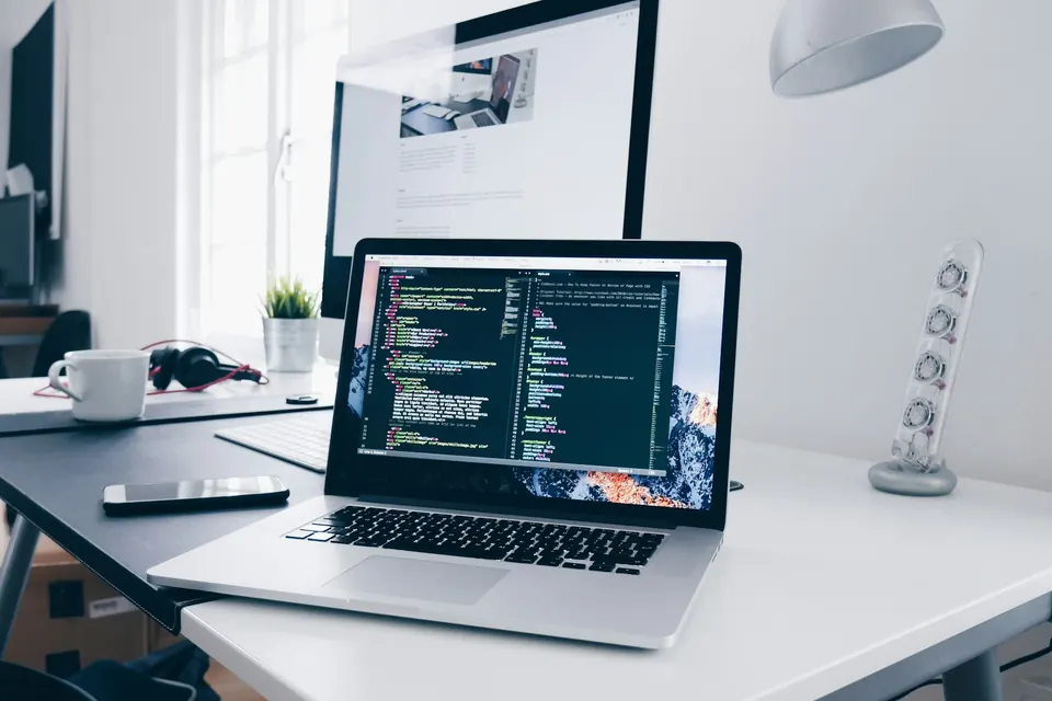 Web design and development: website code on a laptop at an ONS Infosolutions desk